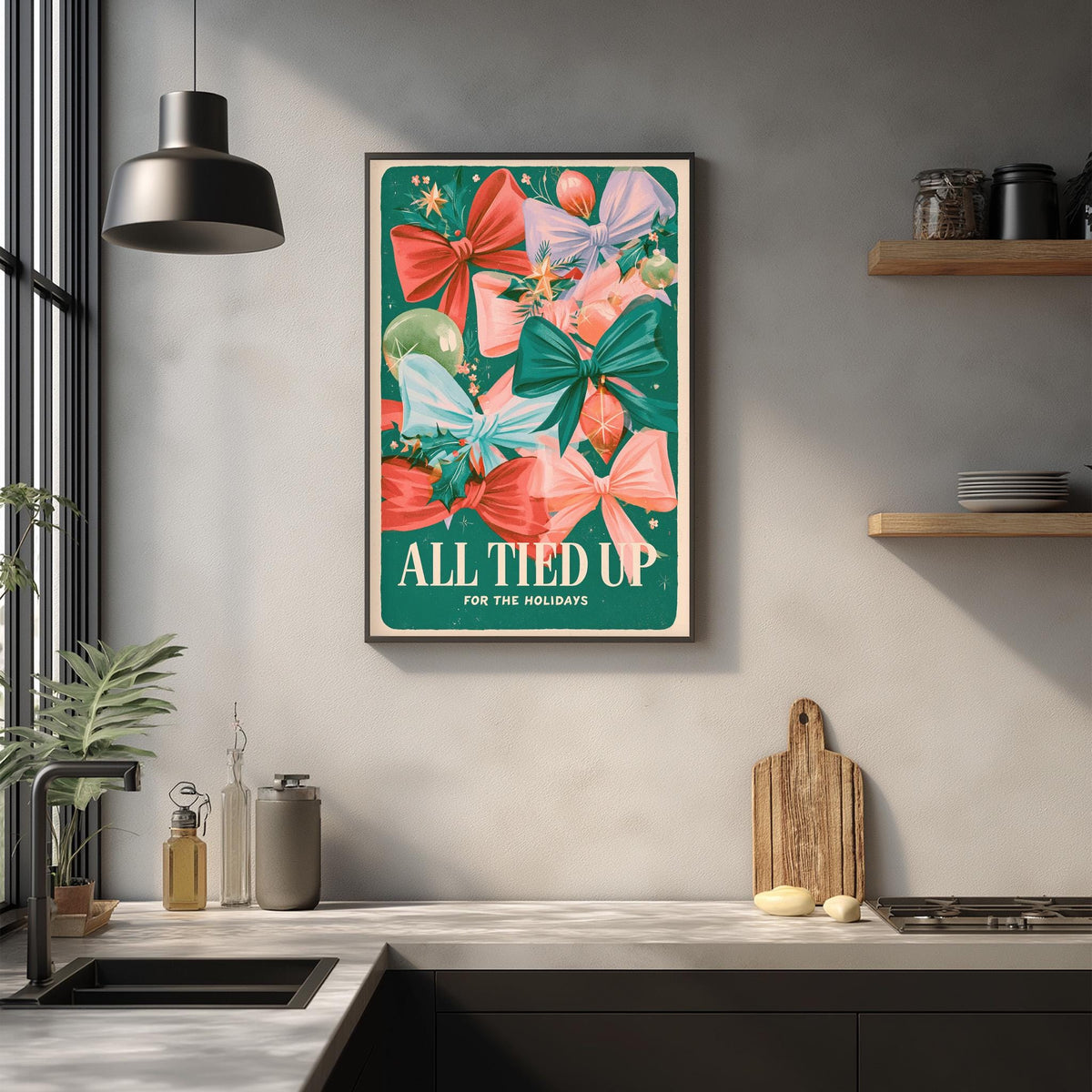a kitchen counter with a framed poster of colorful bows hanging above it. The poster has the text "ALL TIED UP FOR THE HOLIDAYS" written on it.