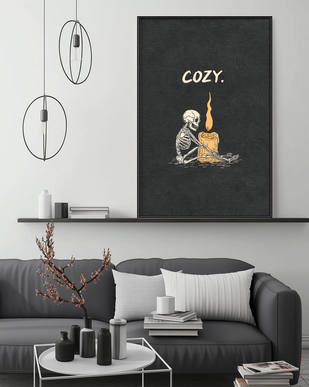 a cozy living room setting with a gray sofa, a coffee table, and a large framed poster with a skeleton and a candle on the wall.