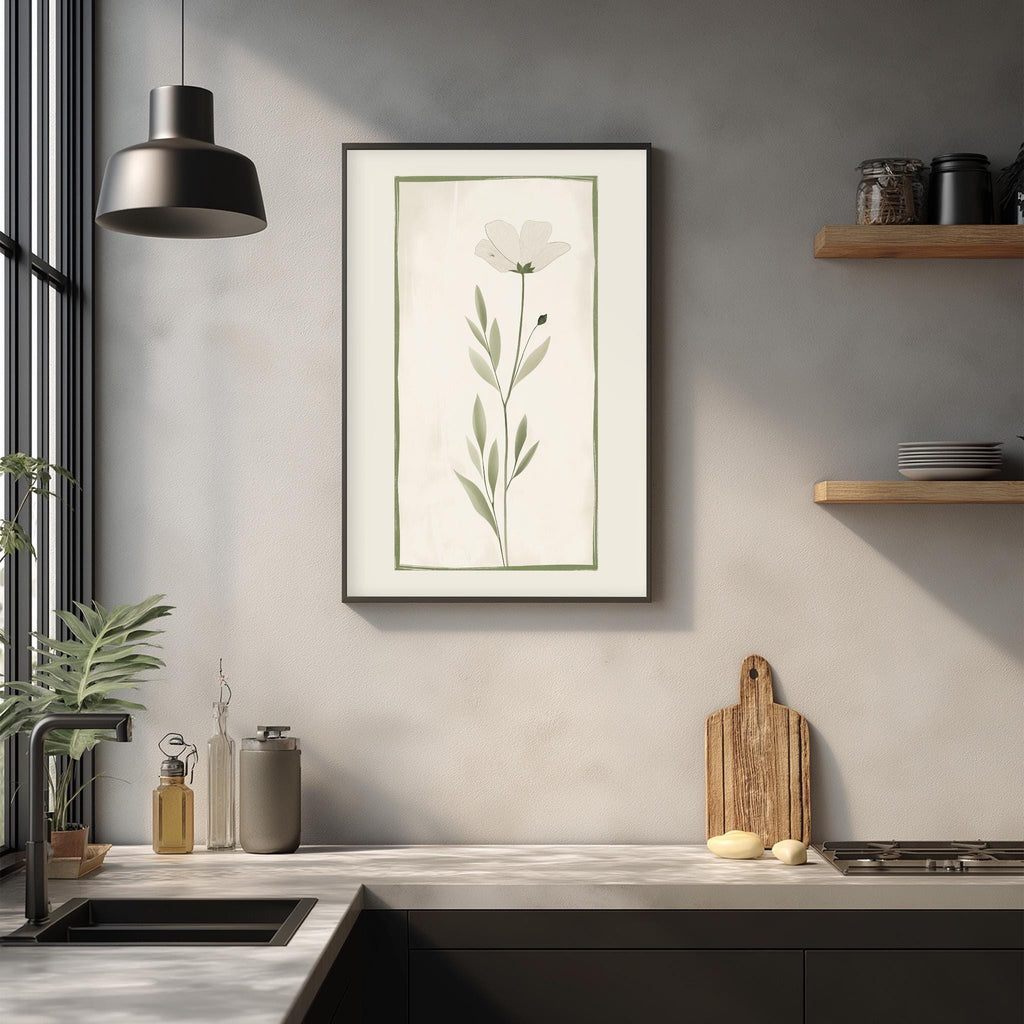 a modern kitchen with a minimalist design, featuring a framed picture of a flower on the wall, a wooden cutting board, and various kitchen accessories such as a bottle, a canister, and a bowl.