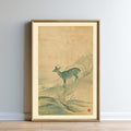 The image is a framed painting depicting a deer standing on a hillside with grass and rocks.