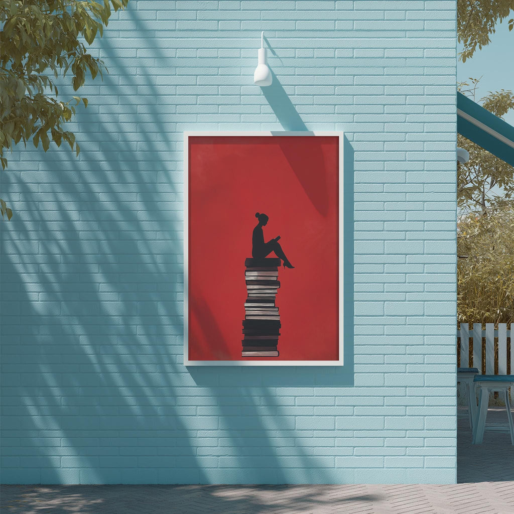A framed image of a person sitting on a stack of books is displayed on a blue wall, with a white light fixture above it.