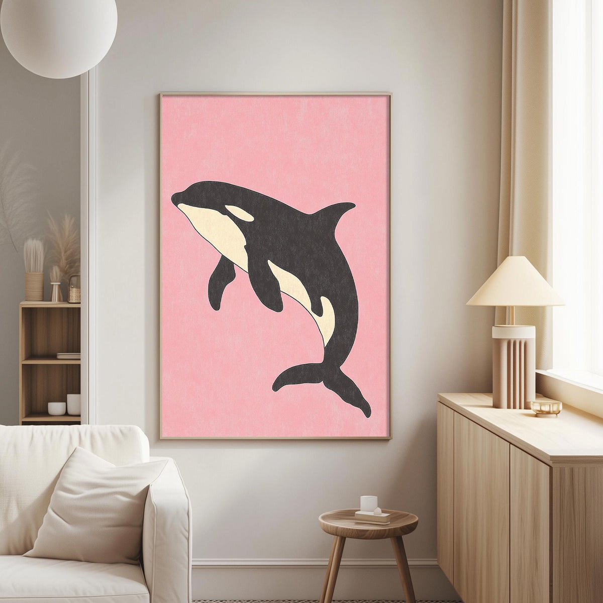 a living room with a large framed poster of a black and white orca whale on a pink background hanging on the wall.