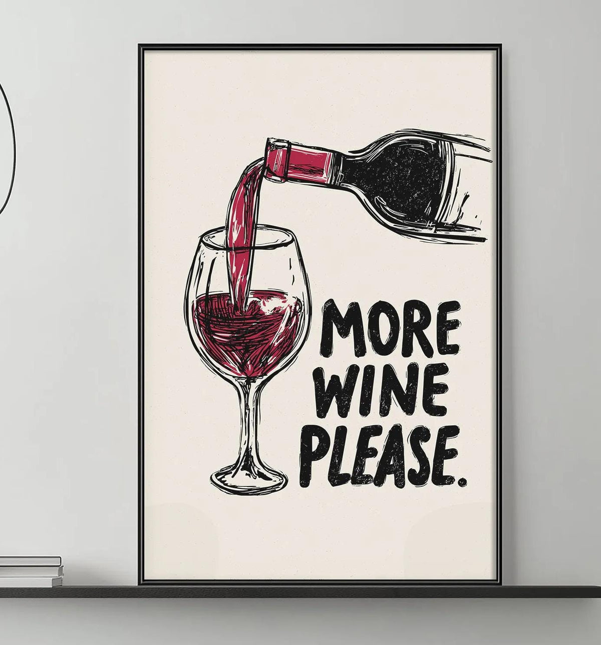 a living room with a gray couch, a coffee table, and a framed poster on the wall that says "MORE WINE PLEASE".