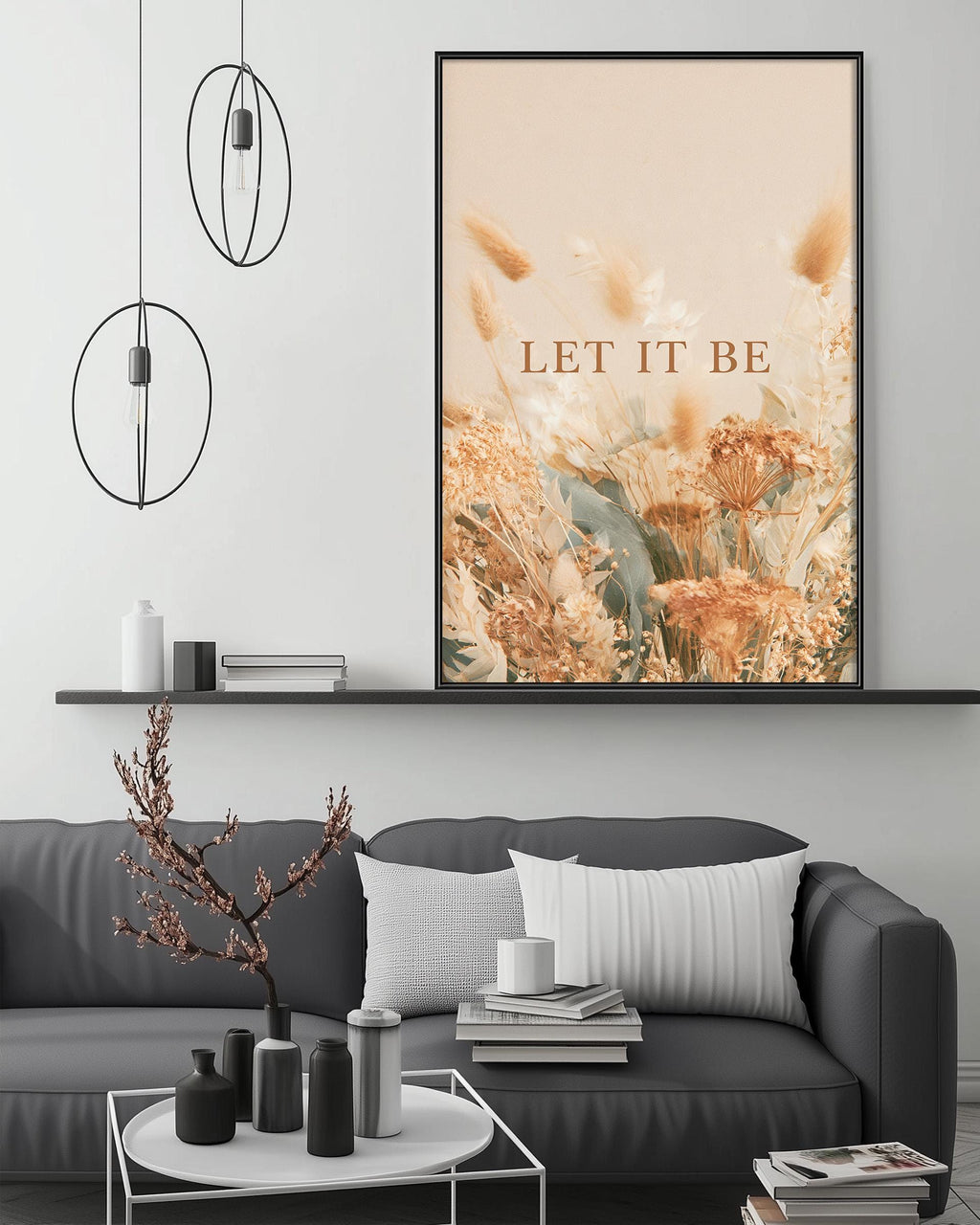 a modern living room with a gray sofa, a coffee table, and a large framed poster with the text "LET IT BE" displayed above it.