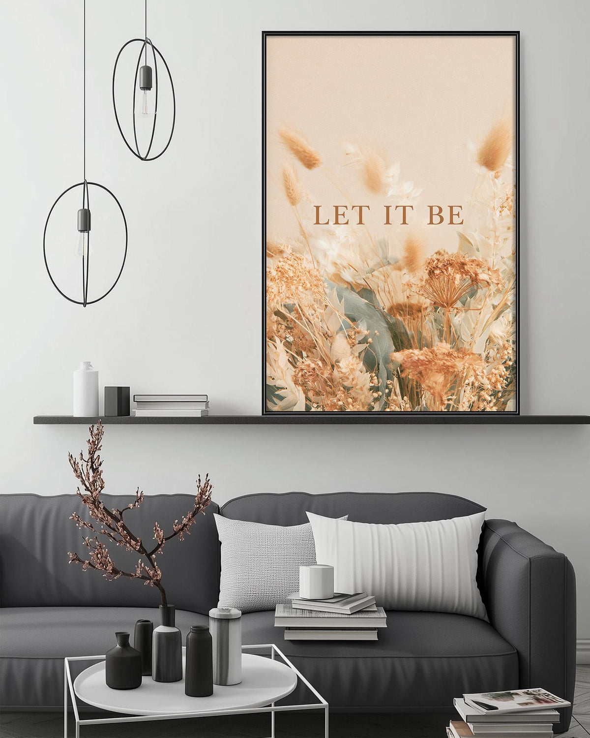 a modern living room with a gray sofa, a coffee table, and a large framed poster with the text "LET IT BE" displayed above it.