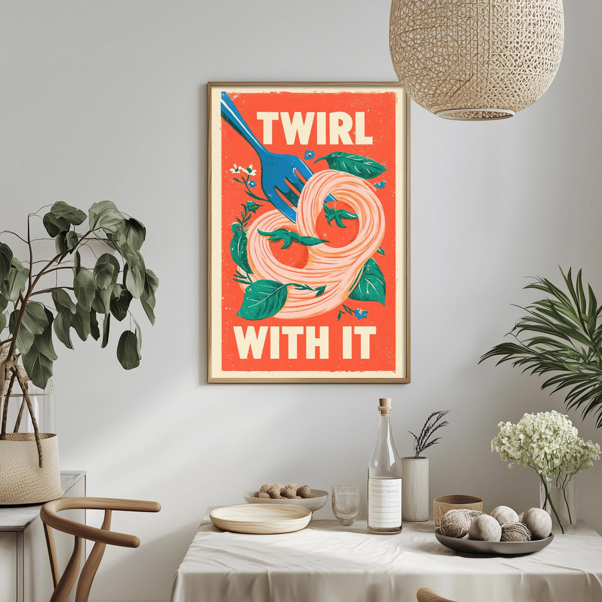 a dining table with a white tablecloth, a bowl of fruit, a bottle, and a vase with flowers. Above the table, there is a framed poster with a vibrant design and the text "TWIRL WITH IT".