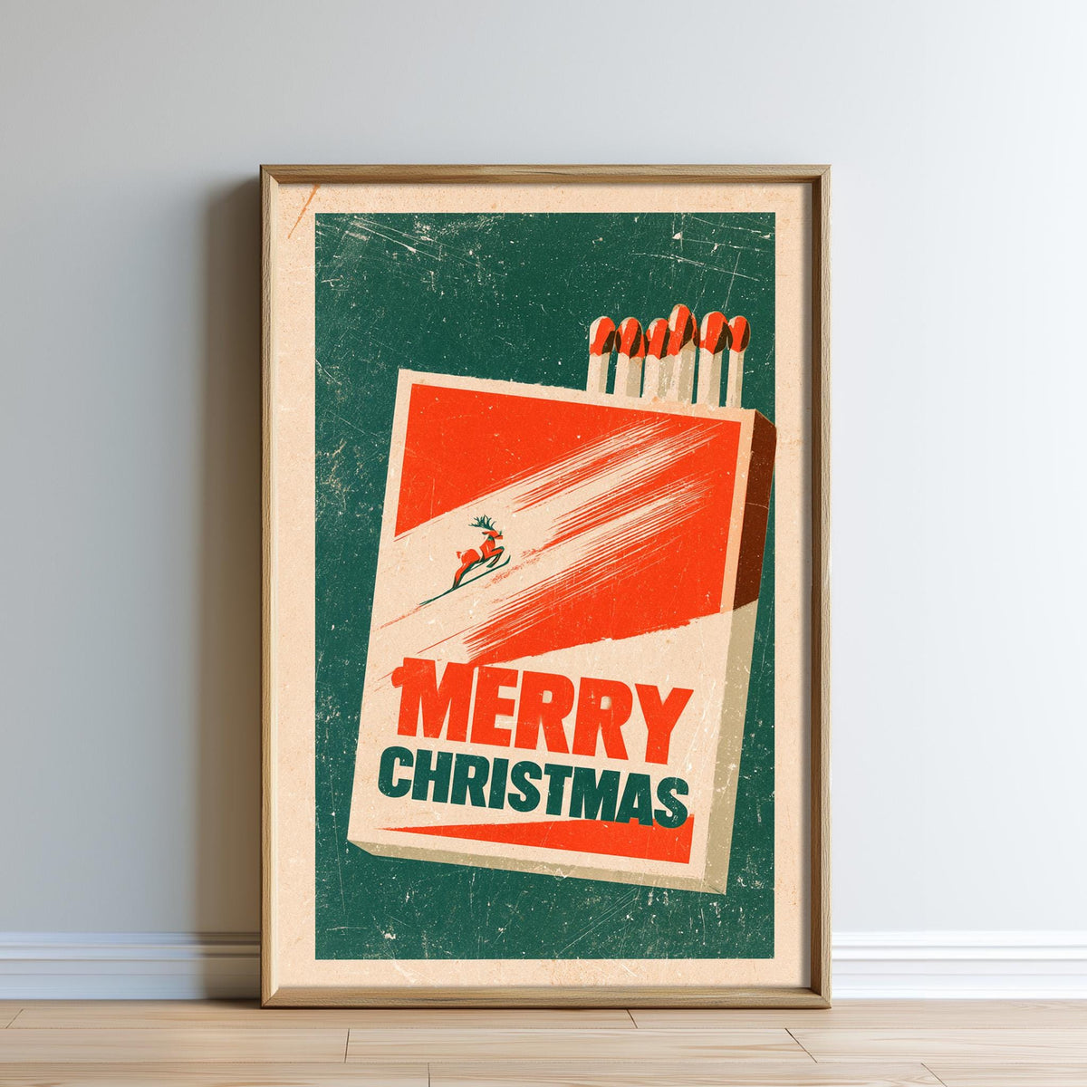 A framed poster with a vintage-style design featuring a red and green background, a large red and white box with a reindeer, and the text "MERRY CHRISTMAS" prominently displayed.