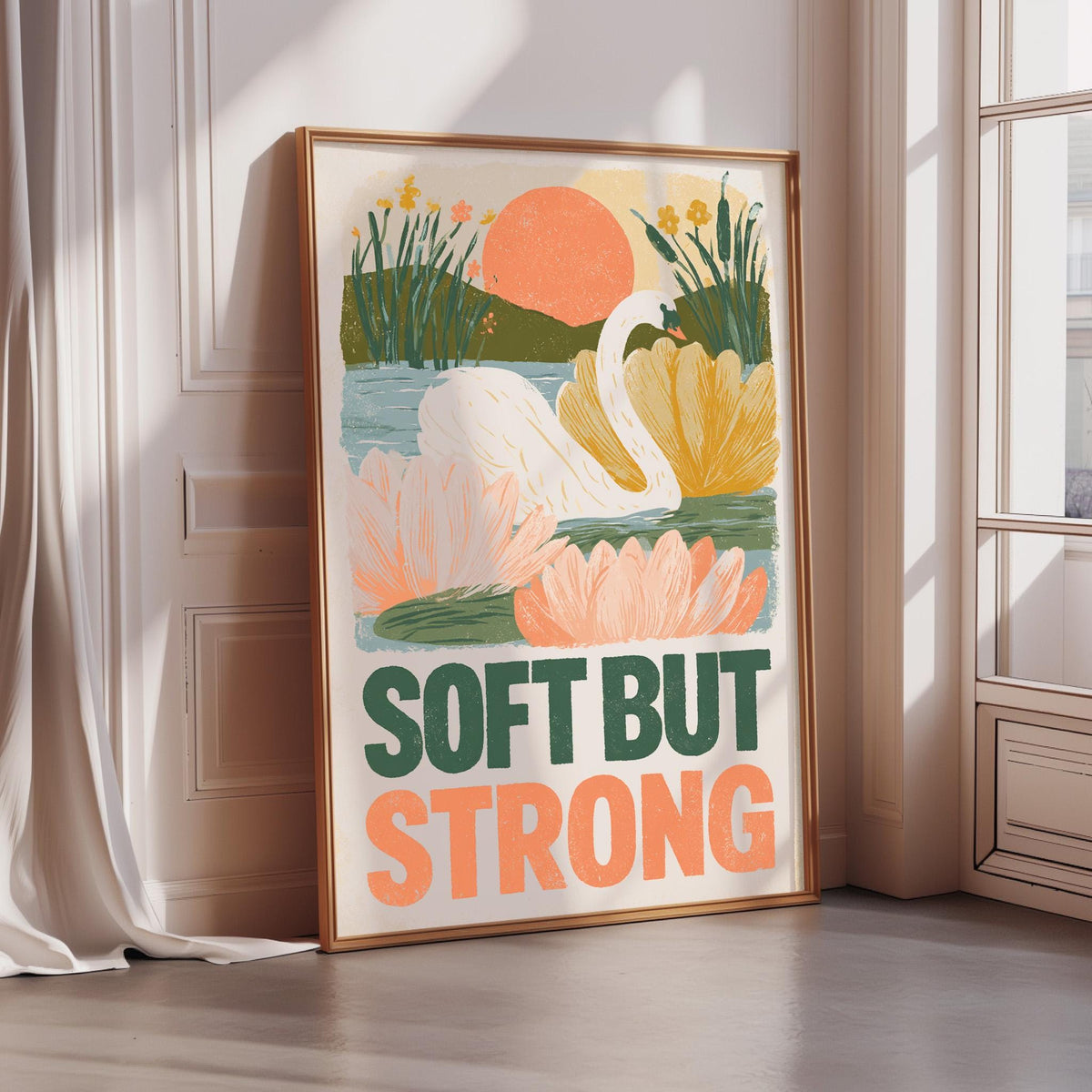 A framed poster with a colorful illustration of a swan and flowers, along with the text "SOFT BUT STRONG" displayed prominently.