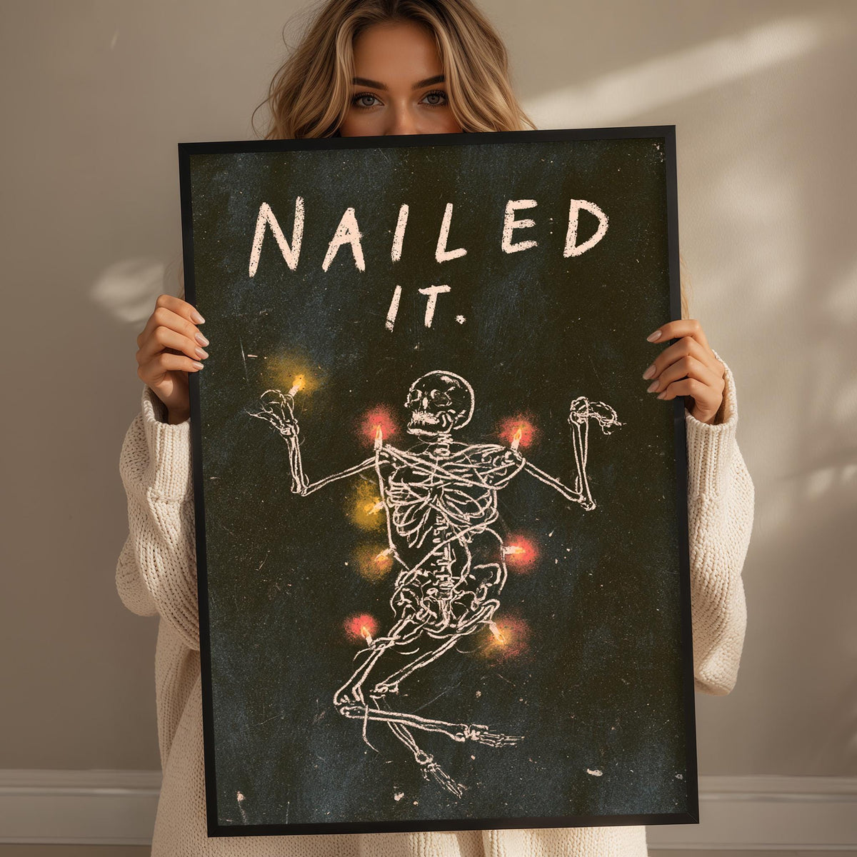 A woman holding a framed poster with a skeleton and the text "Nailed it."