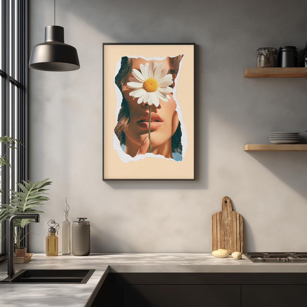 a framed artwork of a woman's face with a large white flower in her eye, hanging on a wall above a kitchen counter.