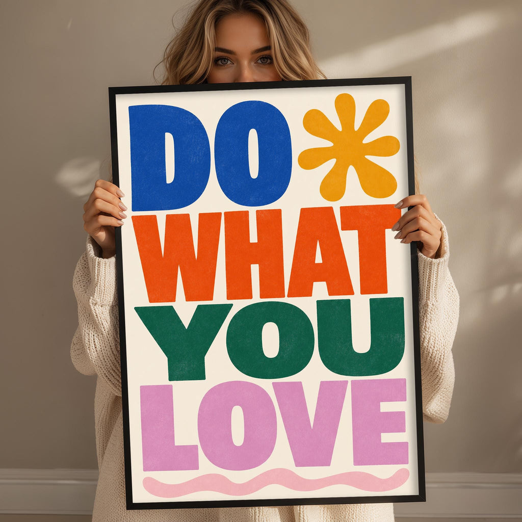 A woman holding a framed poster with the text "DO WHAT YOU LOVE" in a colorful, stylized font.
