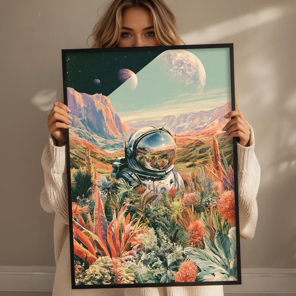 A woman holds up a framed artwork depicting an astronaut in a space landscape with mountains, plants, and a large moon.