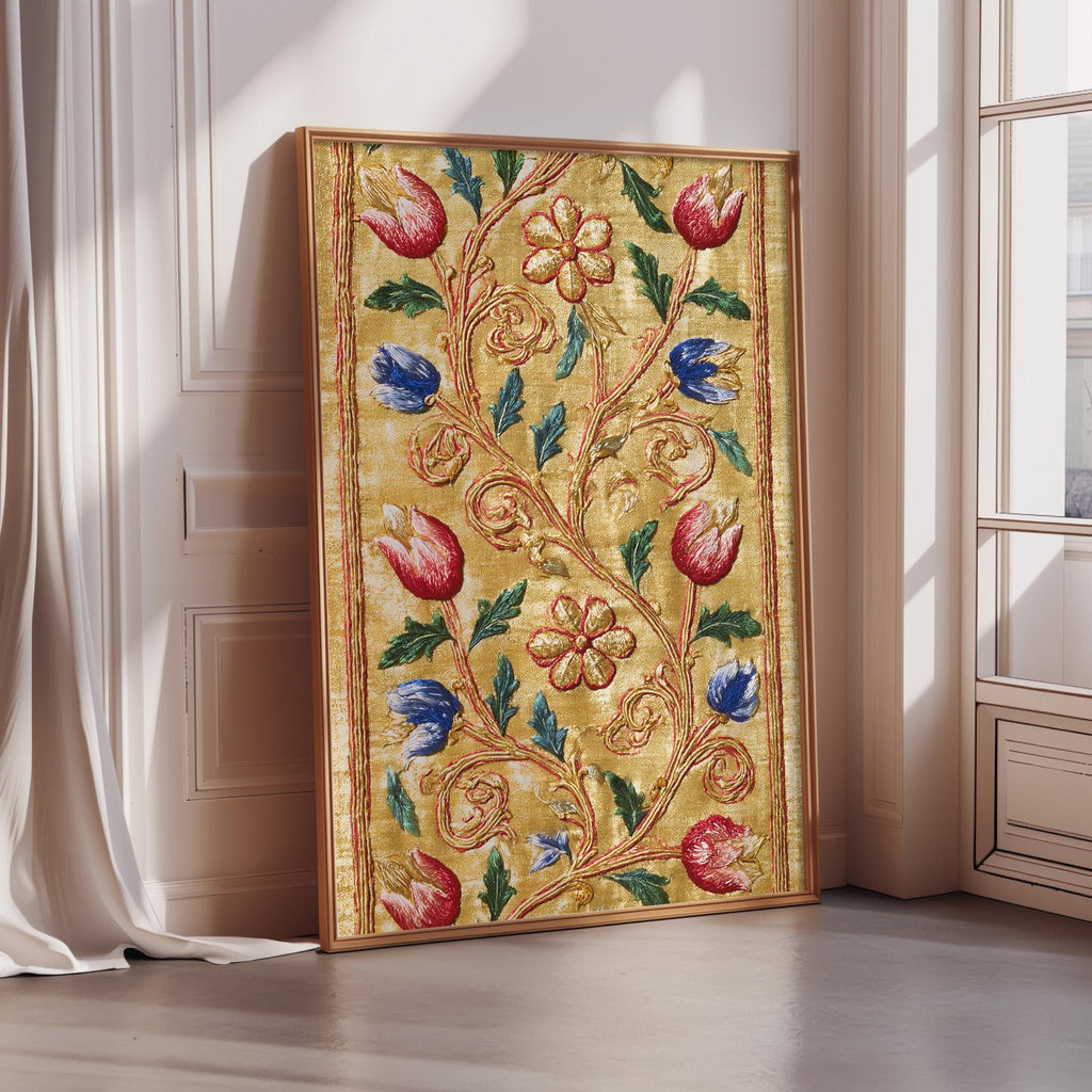 A framed artwork with a gold frame and a vibrant floral design in red, blue, and green colors is displayed on a wall.