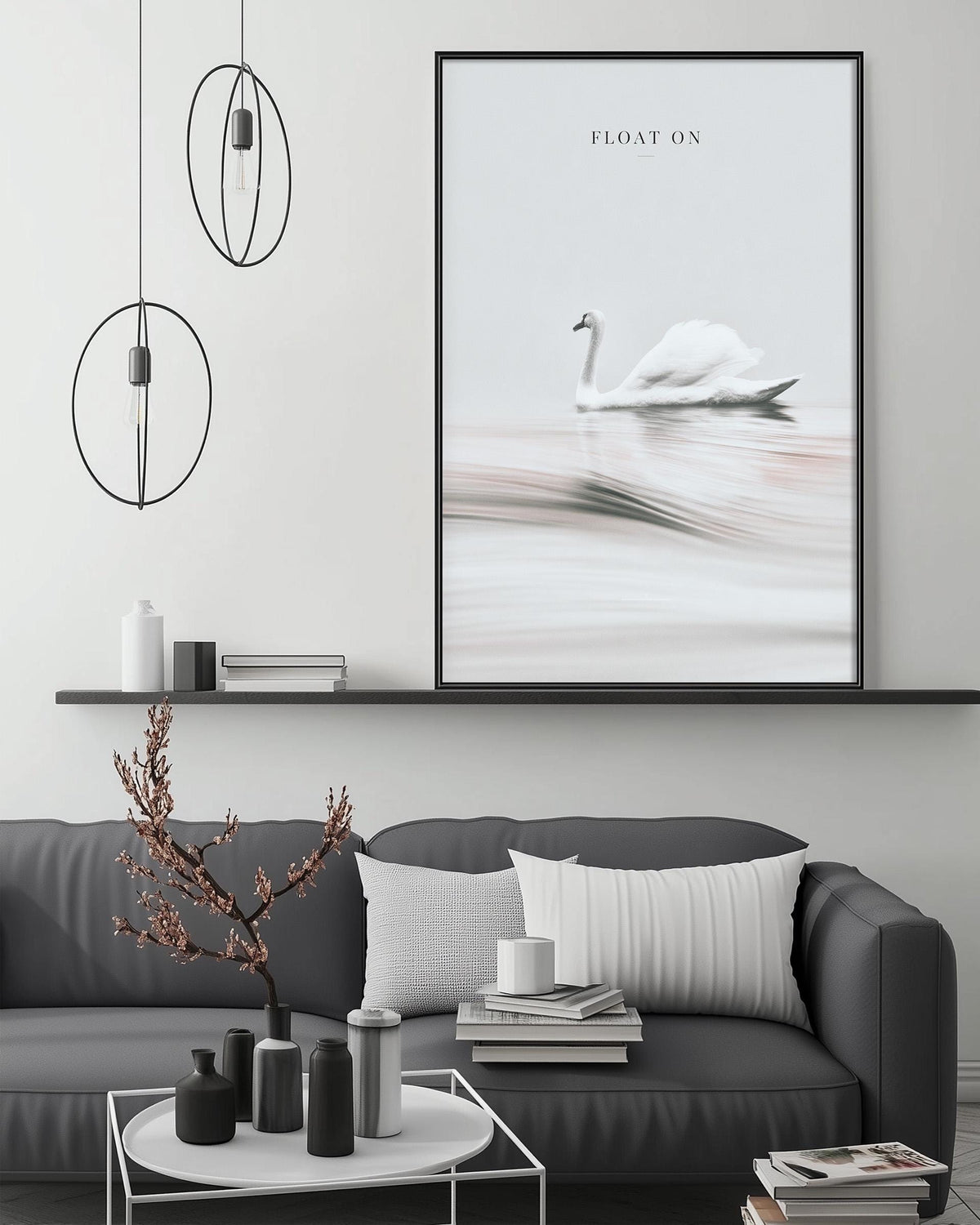 a modern living room with a gray sofa, a coffee table, and a large framed picture of a swan floating on a lake. The room has a minimalist and elegant design, with a black and white color scheme and a few decorative elements such as a potted plant and a vase.