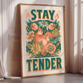 A framed poster with a floral design and the text "STAY TENDER" displayed on it.