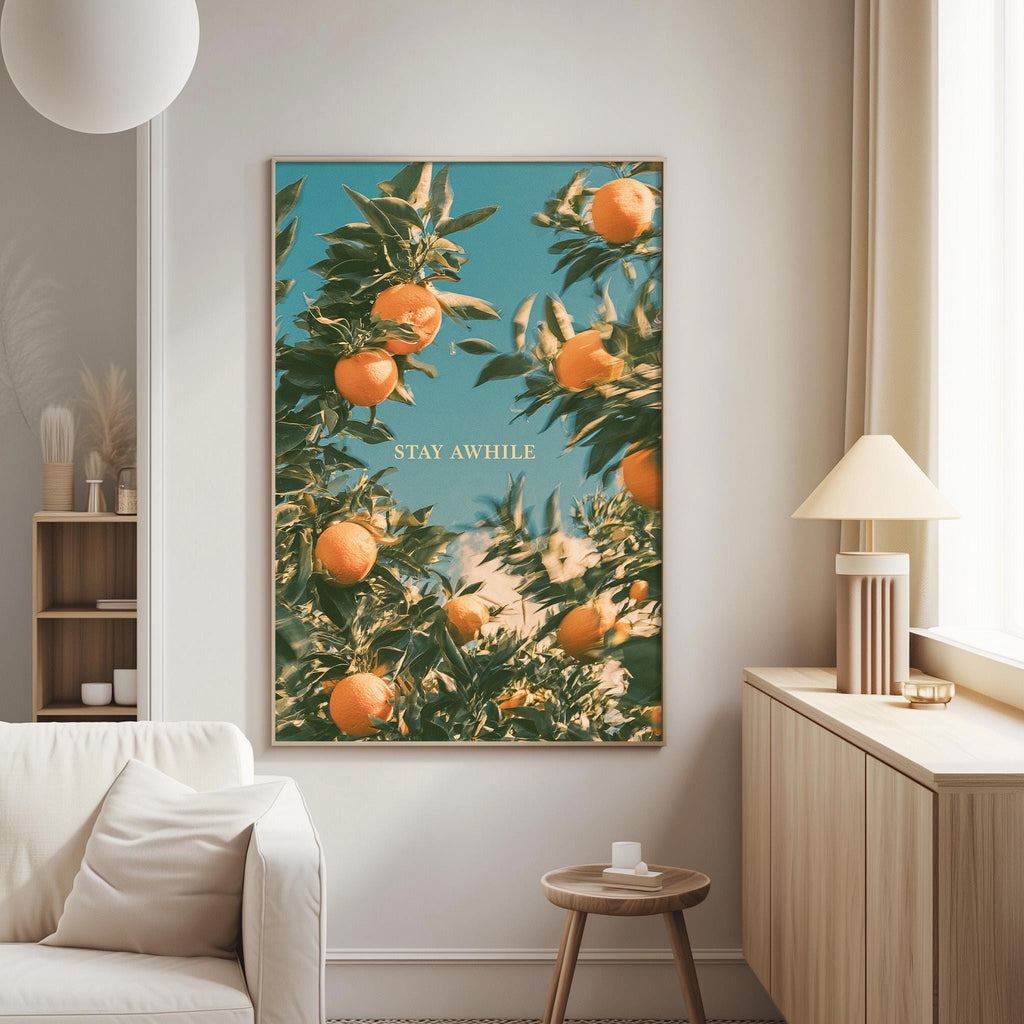 a large framed poster of an orange tree with oranges hanging from its branches, displayed on a wall in a living room setting.