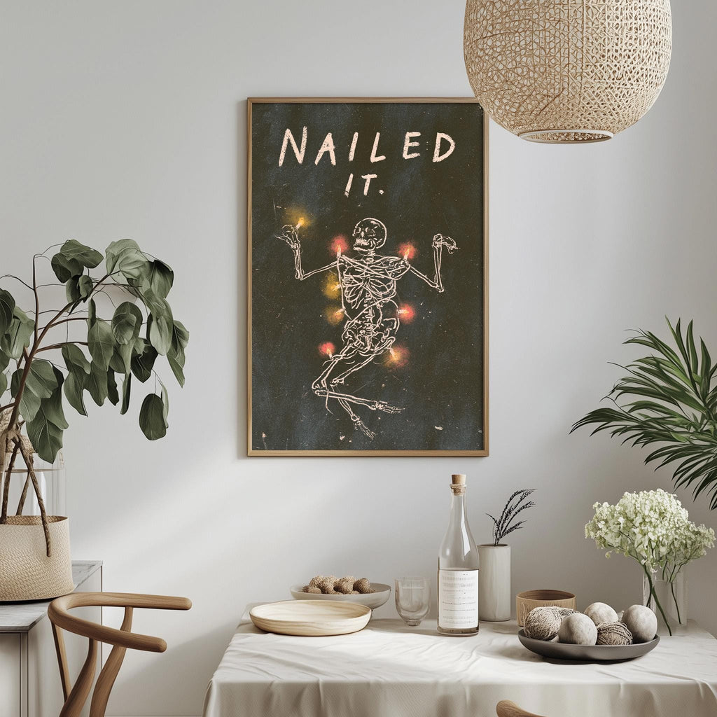a framed poster with a skeleton and a message, hanging on a wall above a table with various items on it.