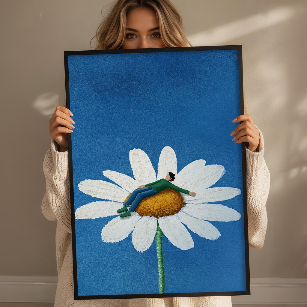 A woman holds up a framed image depicting a person sitting on a large white flower against a blue background.