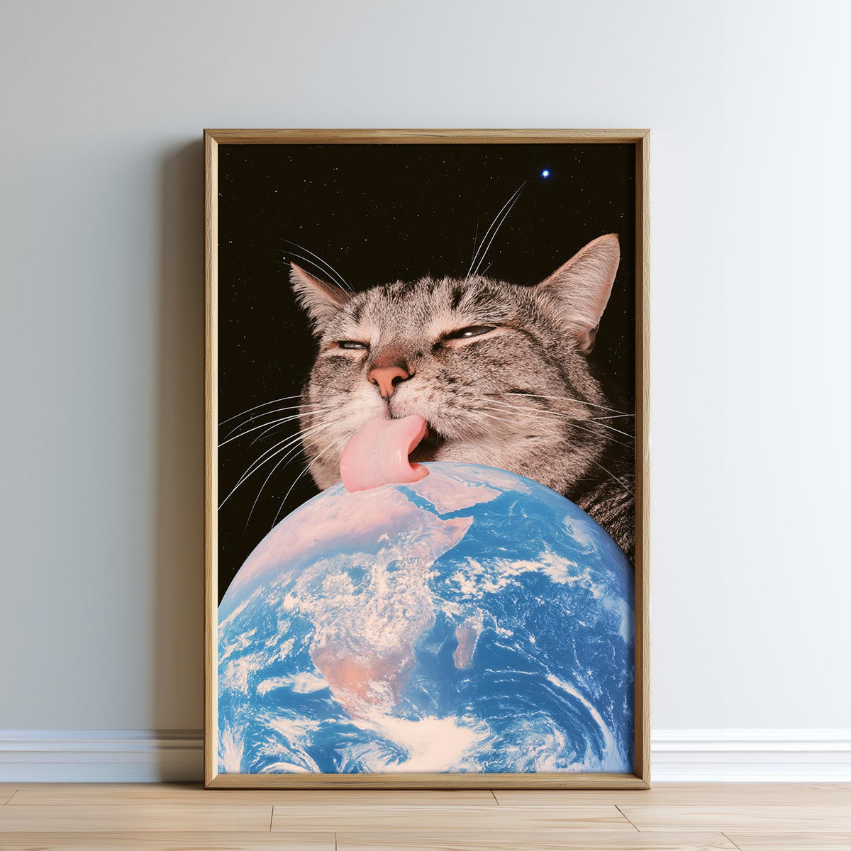 A framed image depicting a cat licking the Earth, with a starry night sky in the background.