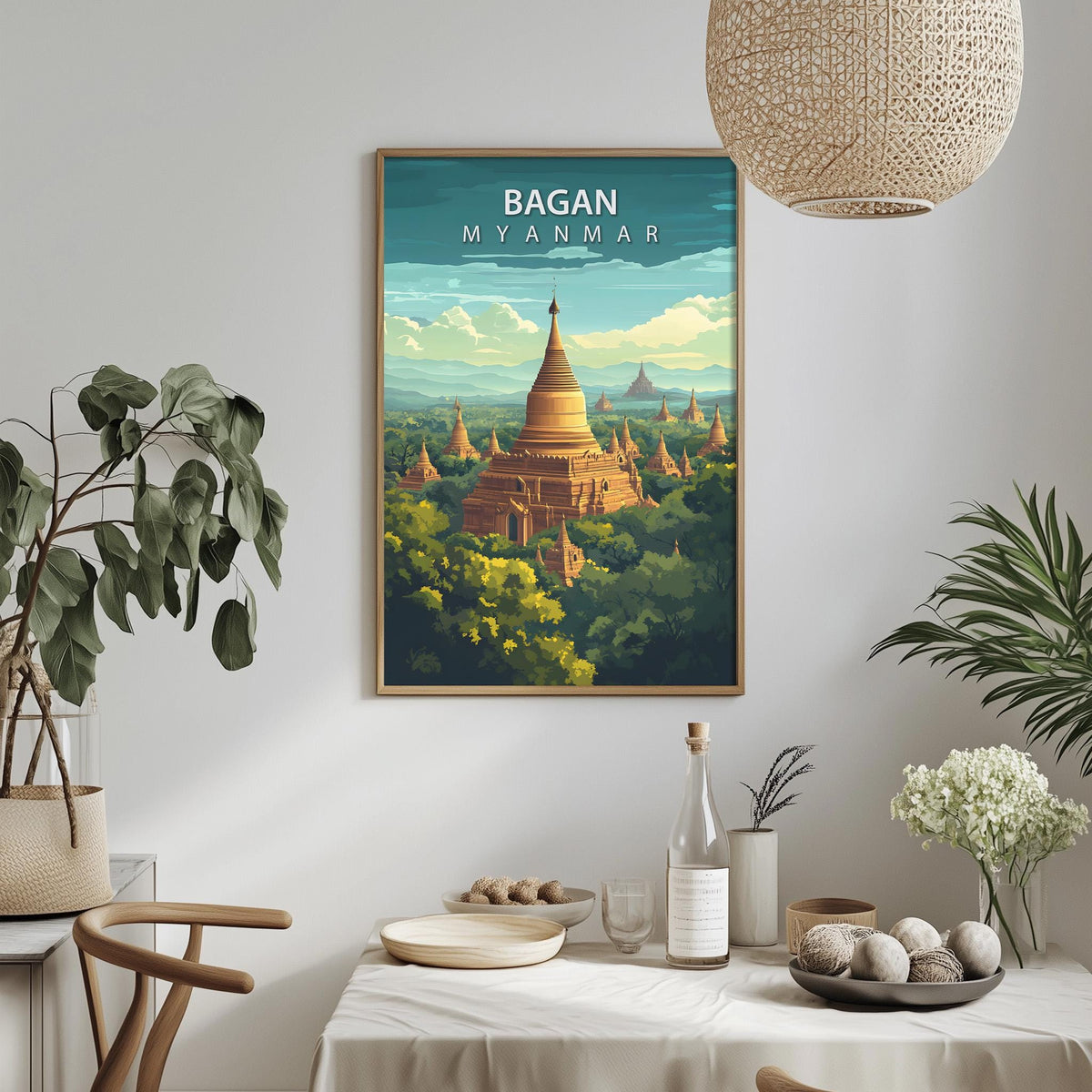 a framed poster of the Bagan, Myanmar, hanging on a wall in a room with a dining table, chairs, and potted plants.