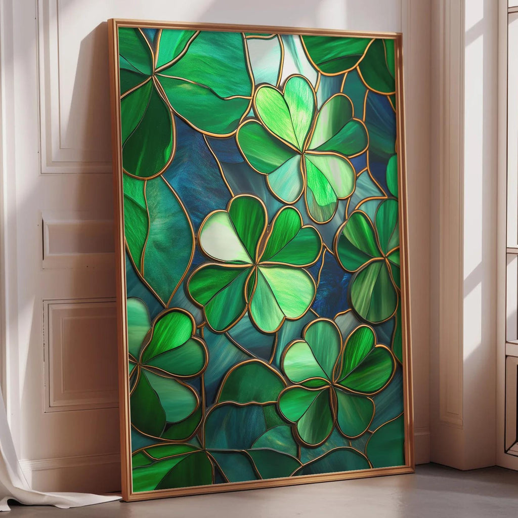 A framed stained glass artwork depicting a vibrant display of green shamrocks is leaning against a white wall in a room with natural light.