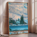 A large framed painting depicting a snowy mountain landscape with a church in the distance, set against a bright blue sky.
