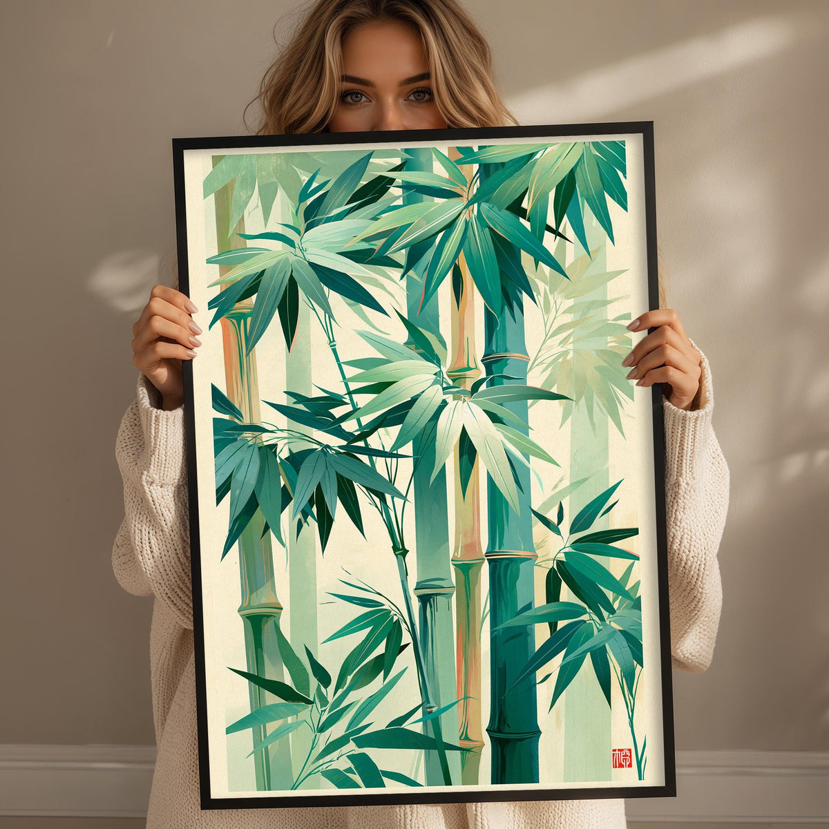 A woman holds up a framed print of a bamboo forest with lush green leaves and stems.