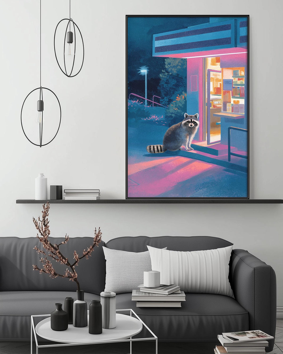a large, colorful painting of a raccoon sitting on a bench outside a building, with a night scene in the background. The painting is hanging on a wall above a gray couch, which has a coffee table in front of it. The room also has some decorative elements, such as pendant lights, a plant, and a bookshelf.