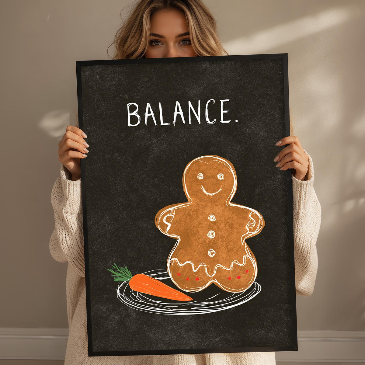 A woman holding a blackboard with a drawing of a gingerbread man and a carrot on it, along with the word "BALANCE" written above.