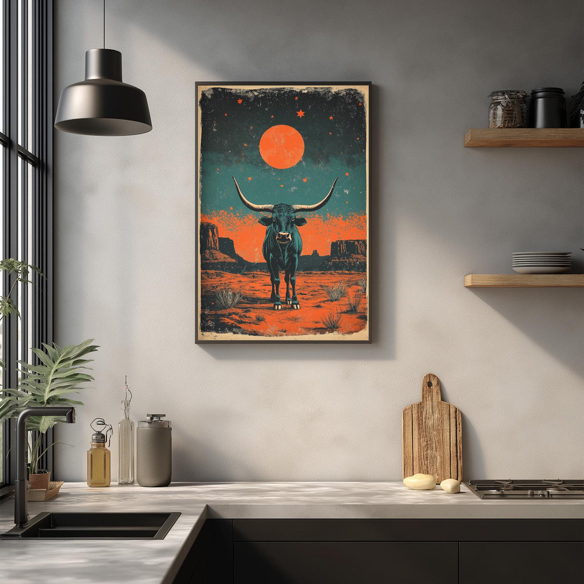 a framed poster of a bull with horns, set against a desert landscape with a red moon and orange stars. The poster is hanging on a wall above a kitchen counter with various kitchen items, such as a cutting board, a bottle, and a vase.