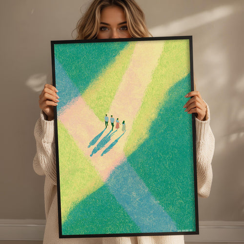 A woman holding a framed picture of a group of people standing in a field with a colorful abstract background.
