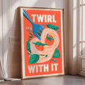 a framed poster with a vibrant design of a fork and noodles, accompanied by the text "TWIRL WITH IT" in bold letters.