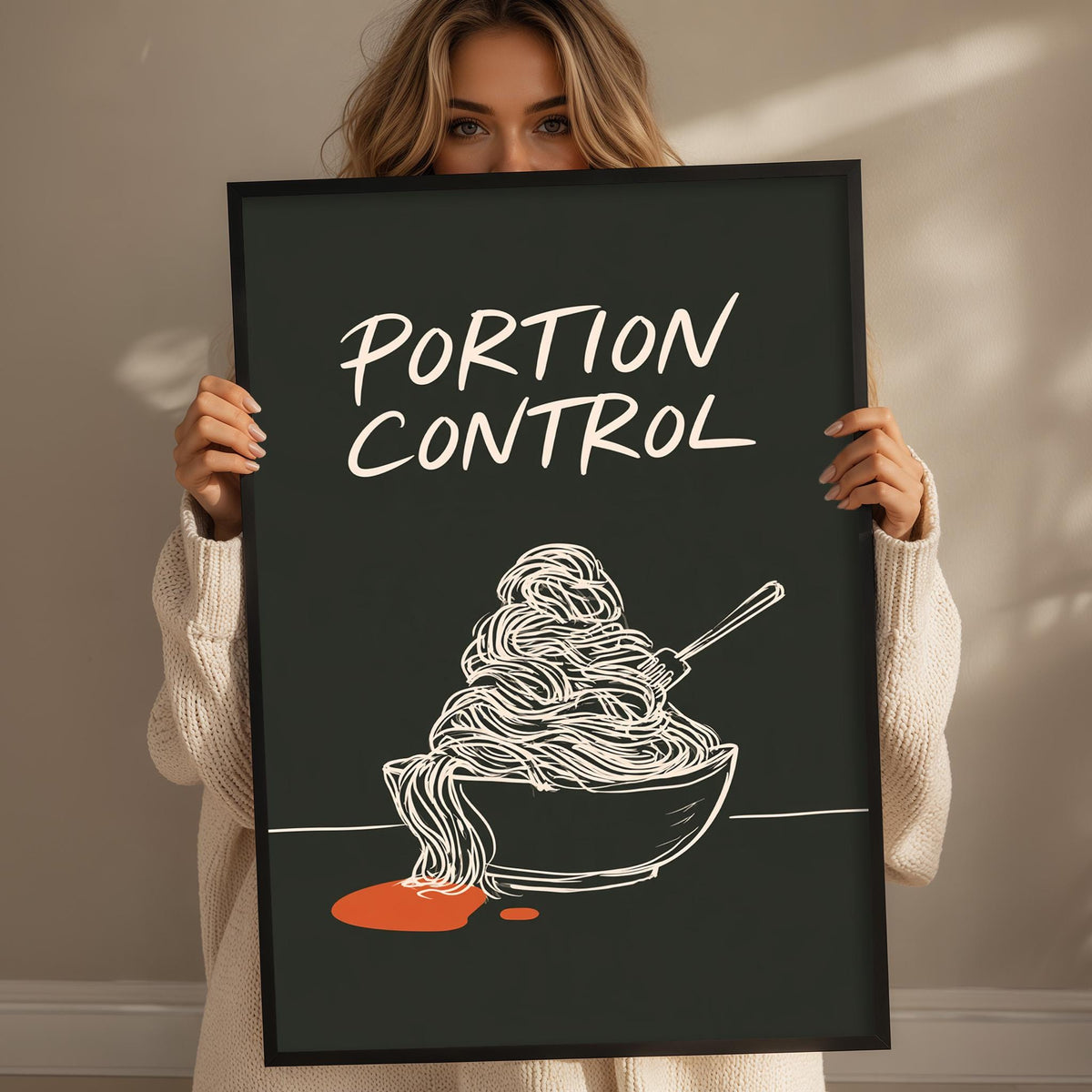 A woman holding a framed poster with the text "PORTION CONTROL" and an illustration of noodles in a bowl.