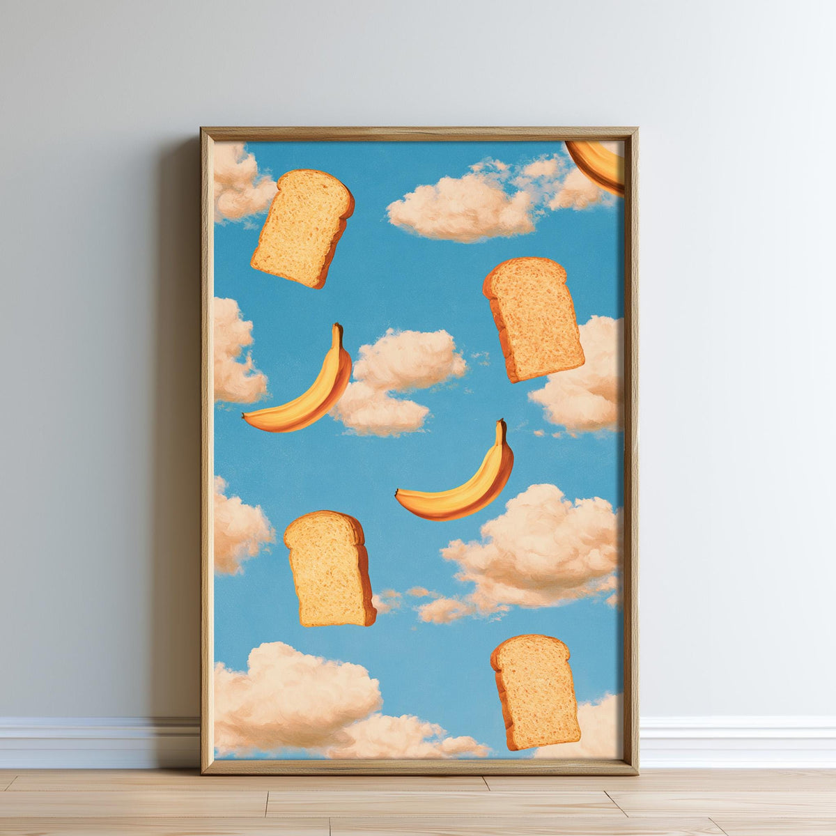 The image is a framed print featuring a whimsical scene of bread and bananas floating in a blue sky with fluffy white clouds.