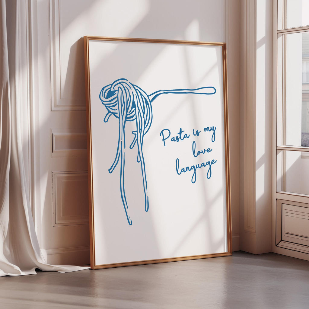 A framed poster with a blue illustration of spaghetti noodles and the text "Pasta is my love language" is displayed on a wall.