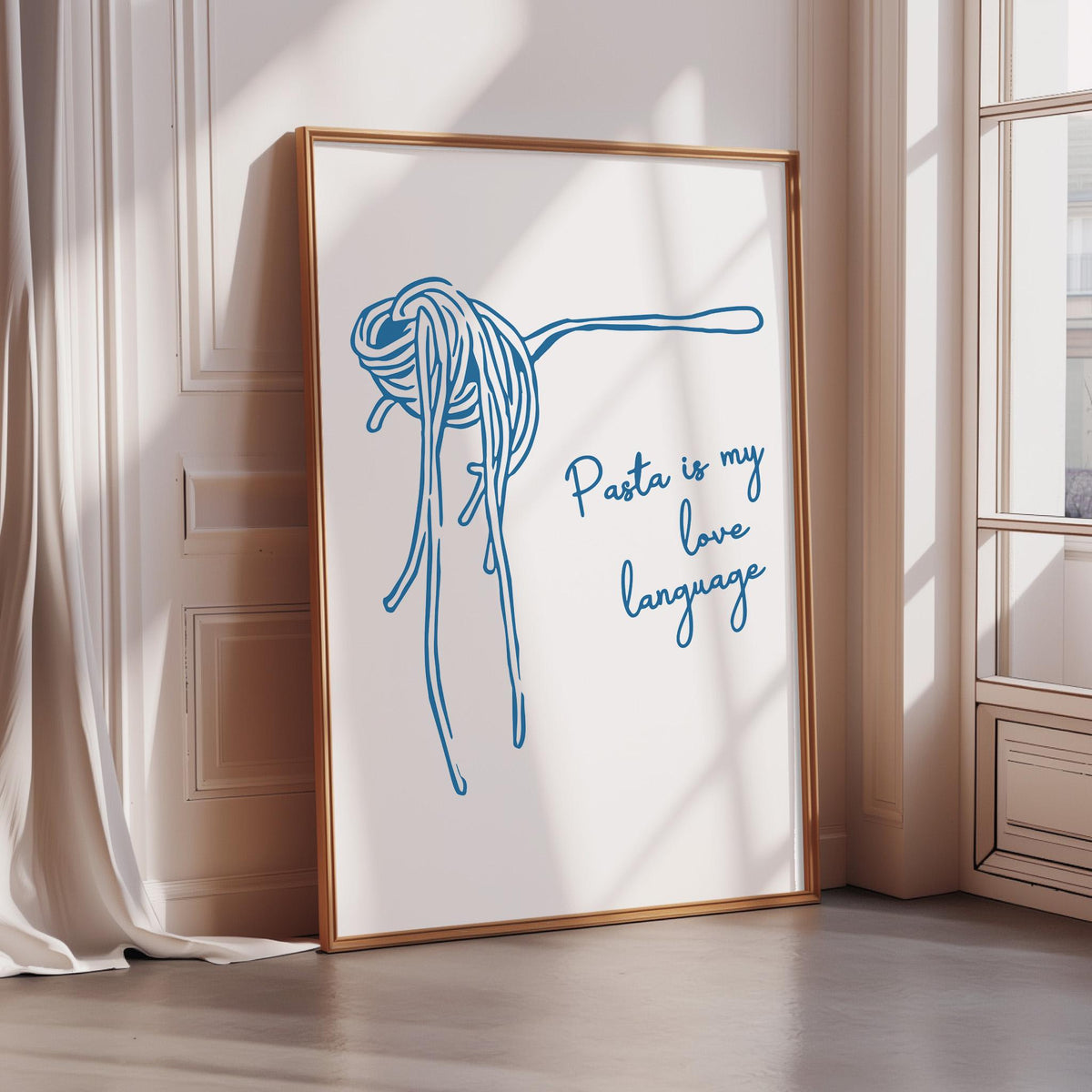 A framed poster with a blue illustration of spaghetti noodles and the text "Pasta is my love language" is displayed on a wall.