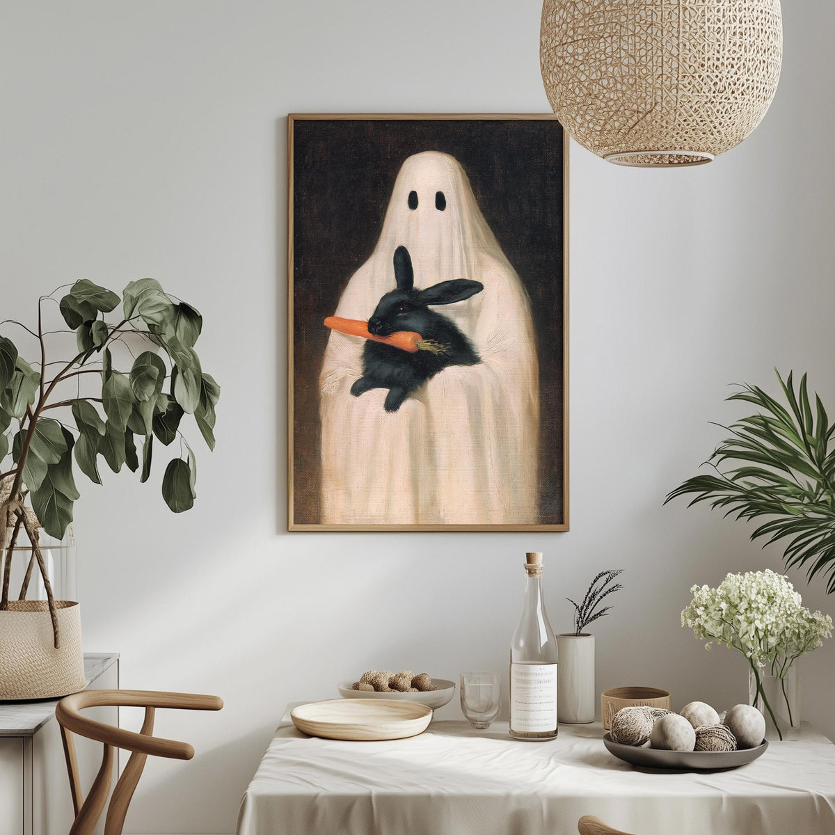 a painting of a ghost holding a black rabbit, hanging on a wall above a table with various items on it.