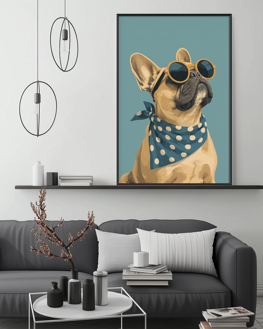 a large framed picture of a dog wearing sunglasses and a polka dot scarf, hanging on a wall above a gray couch with a coffee table in front of it.
