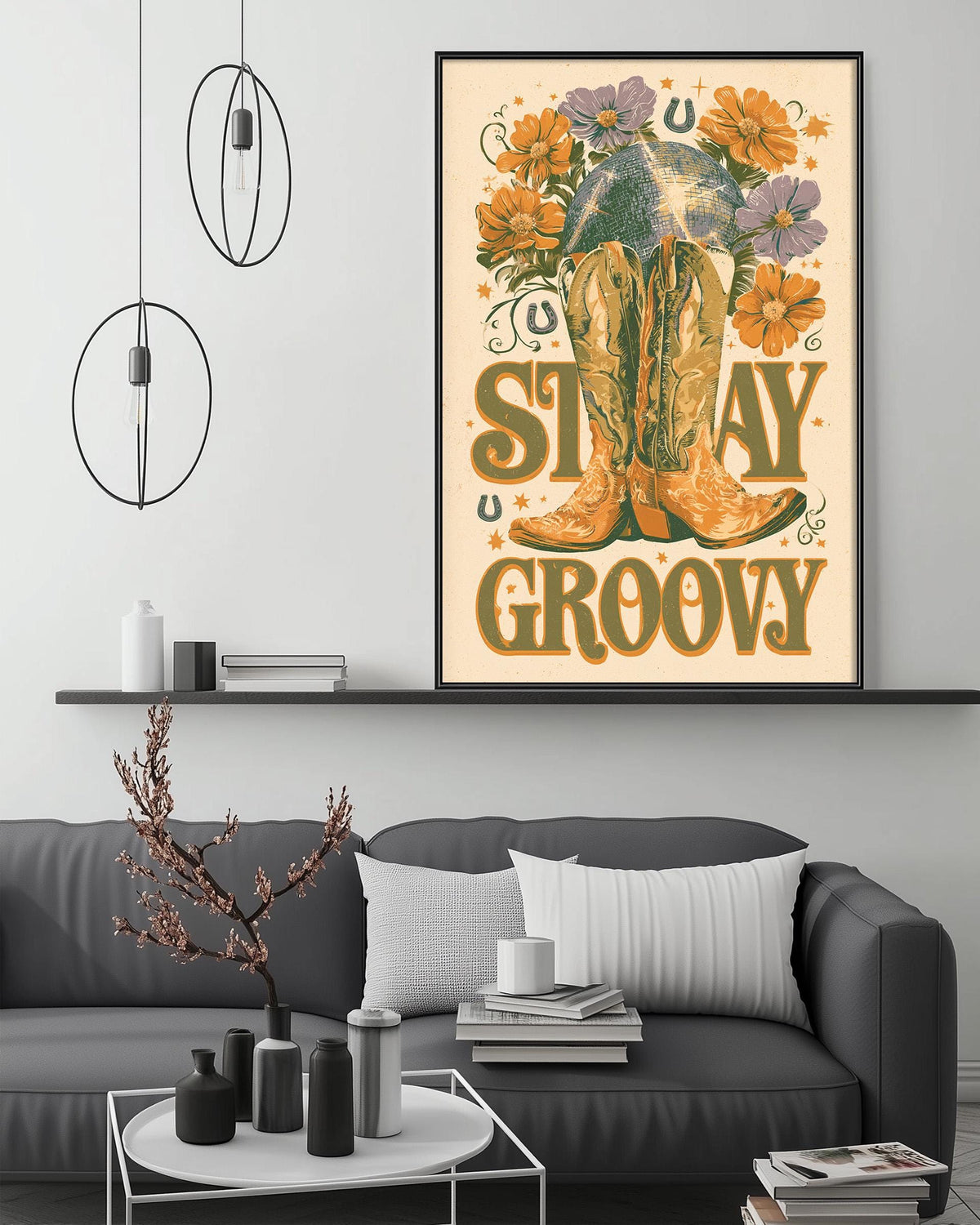 a poster with a cowboy boot and flowers, hanging on a wall above a gray couch with a coffee table in front of it.