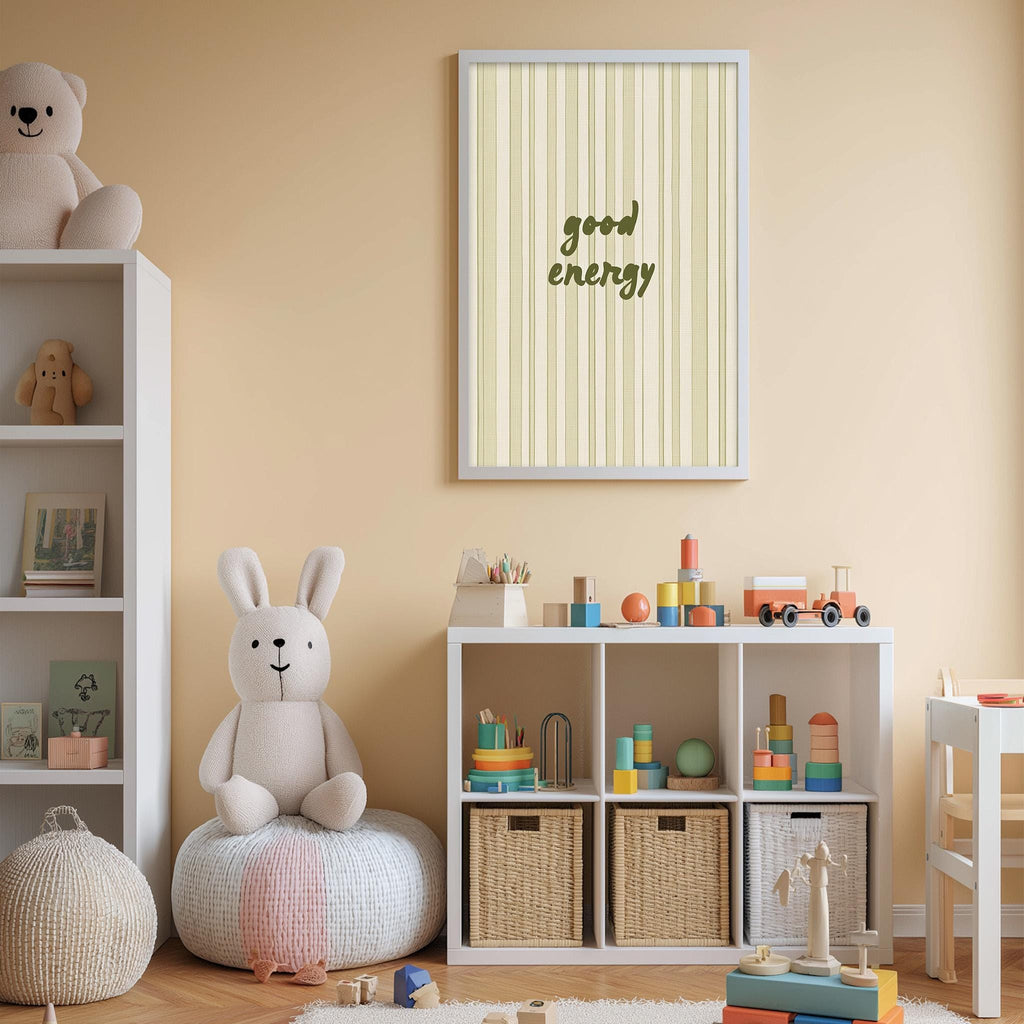 A cozy and colorful children's playroom with a stuffed rabbit, a bookshelf, and a toy train set. The walls are painted a light peach color, and there is a framed quote that reads "good energy" above the play area.