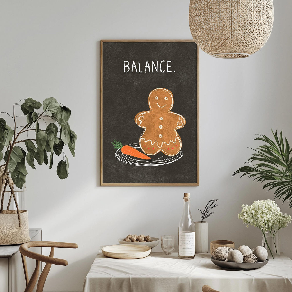a dining table with a white tablecloth, a bowl of fruit, a bottle, and a vase with flowers. Above the table, there is a framed image of a gingerbread man with a carrot on its plate.
