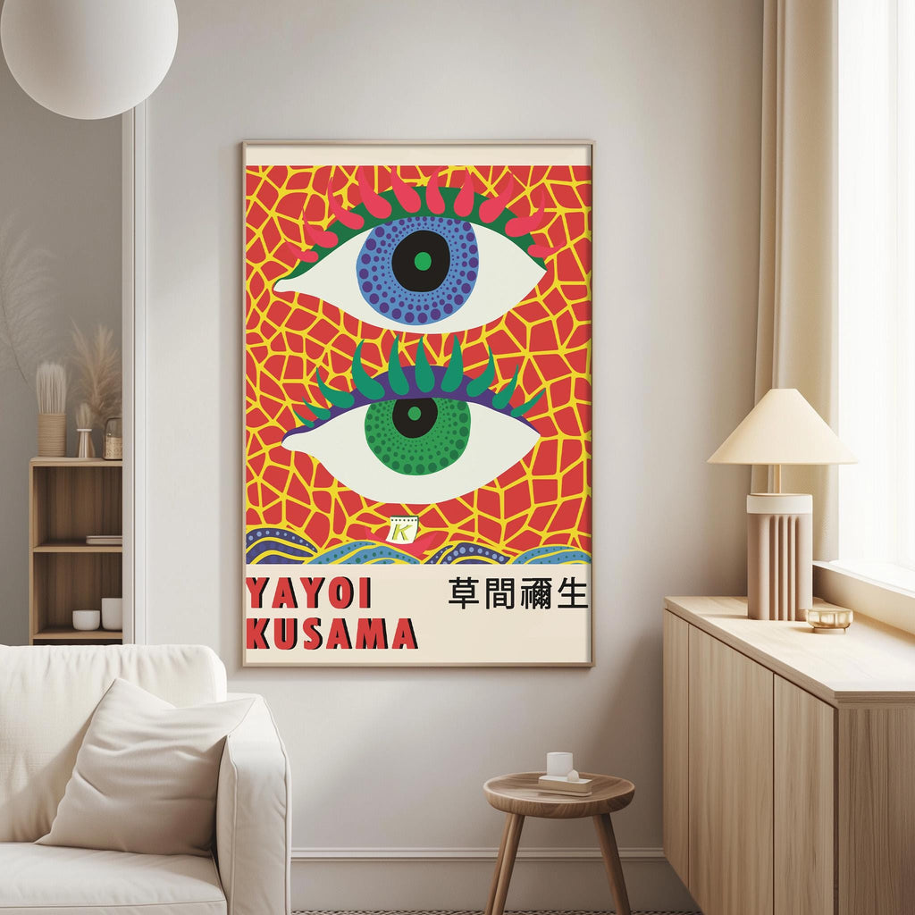 a vibrant poster of Yayoi Kusama's artwork, which includes two large eyes with green and blue accents against a colorful, abstract background. The poster is hanging on a wall in a living room setting, with a white couch and a small table nearby.