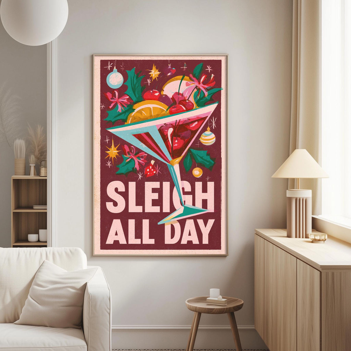 a poster with a festive design, including a martini glass filled with various fruits and a "Sleigh All Day" message. The poster is displayed on a wall in a living room setting, with a white couch and a lamp visible in the background.