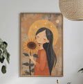 a framed illustration of a woman holding a sunflower, hanging on a wall above a dining table with various decorative items and plants.