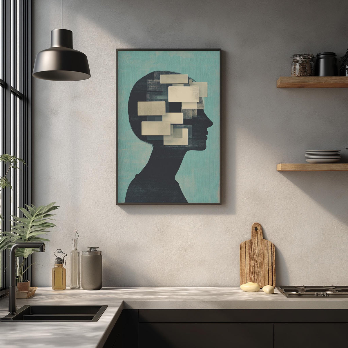 a kitchen counter with various items on it, including a framed artwork depicting a silhouette of a person's head, a wooden cutting board, and a potted plant.