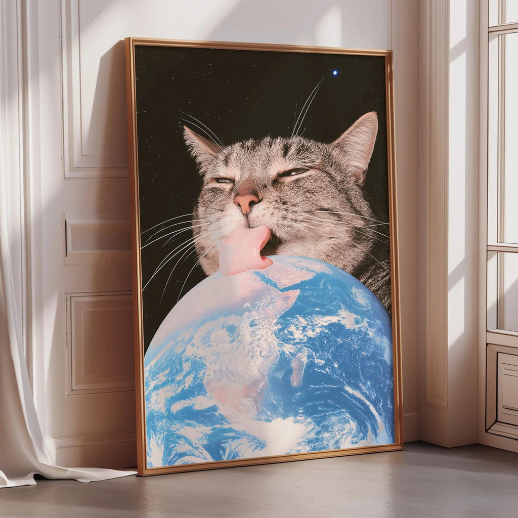 A framed image depicting a cat licking the Earth, with a starry night sky in the background.
