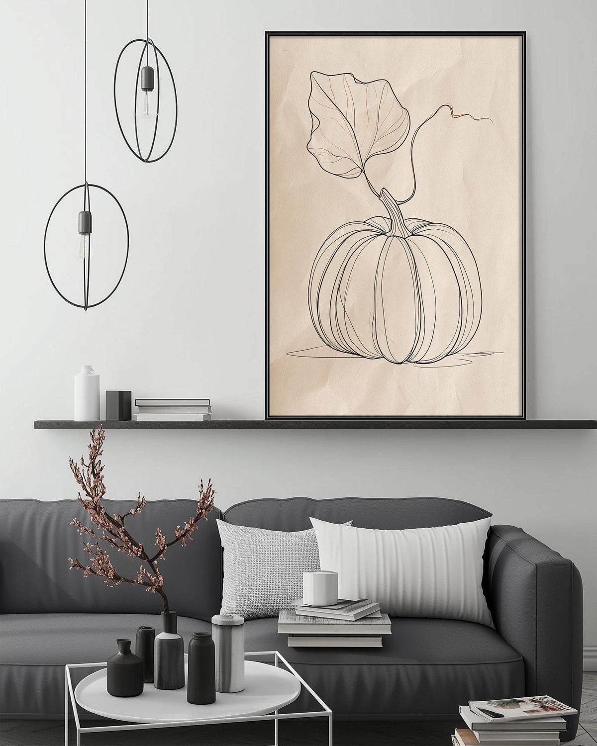 a living room with a gray sofa, a coffee table, and a large framed drawing of a pumpkin on the wall above the sofa.