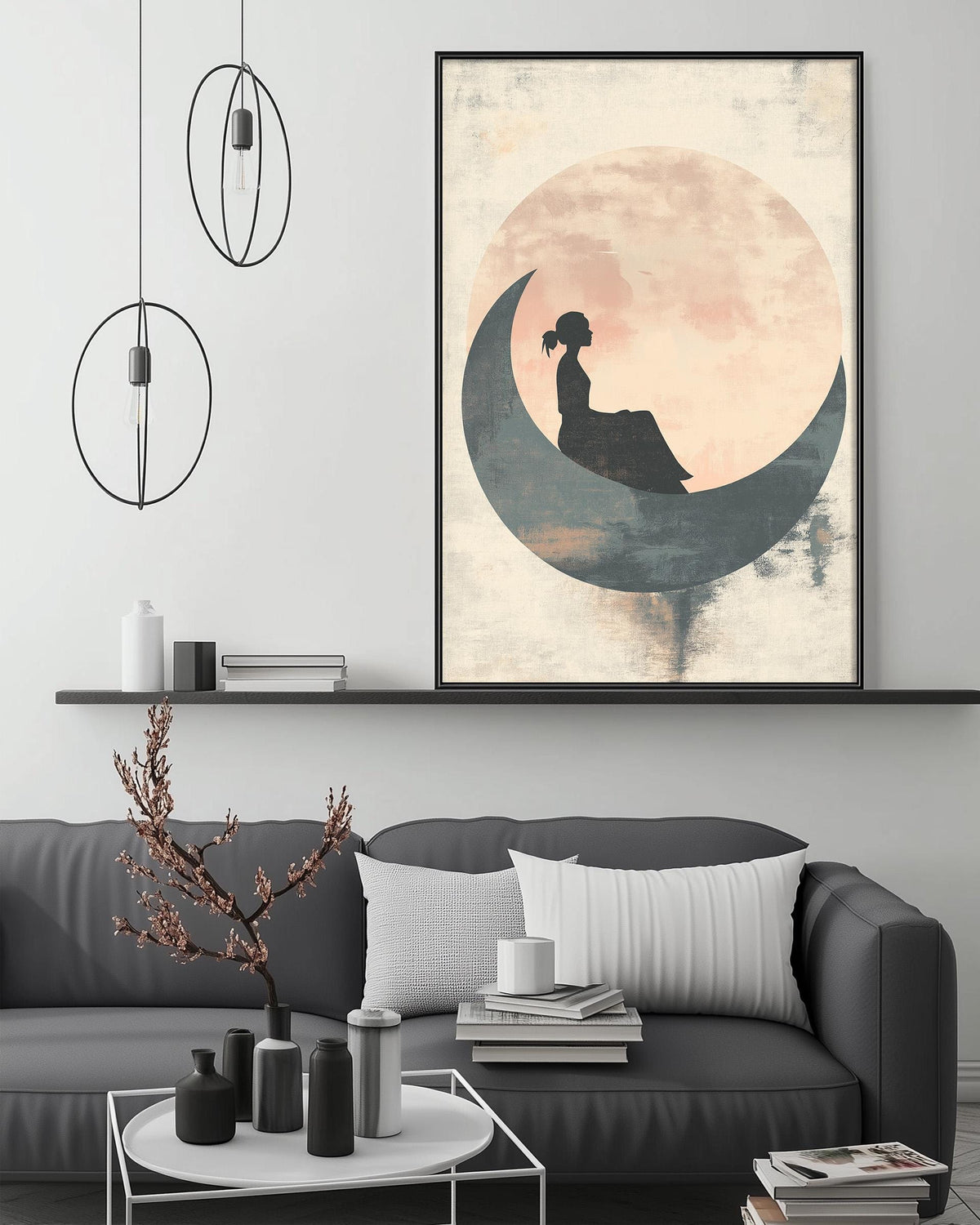 a living room with a gray sofa, a coffee table, and a large framed print of a woman sitting on a crescent moon. The room has a minimalist and modern design, with a pendant light hanging above the sofa and a shelf displaying decorative items.