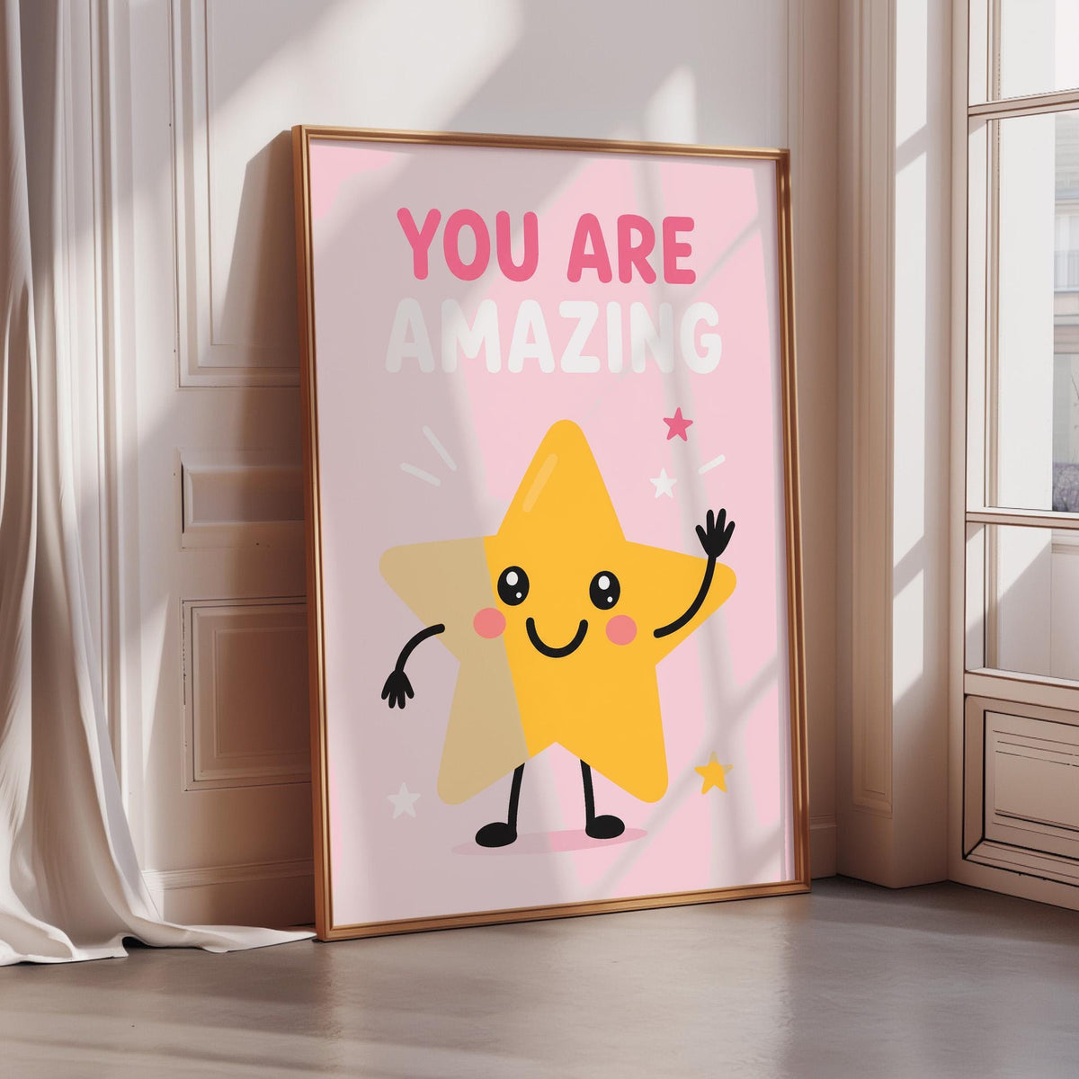 A framed poster with a cheerful yellow star character and the text "YOU ARE AMAZING" on it, placed on a wooden floor in a room with a window.