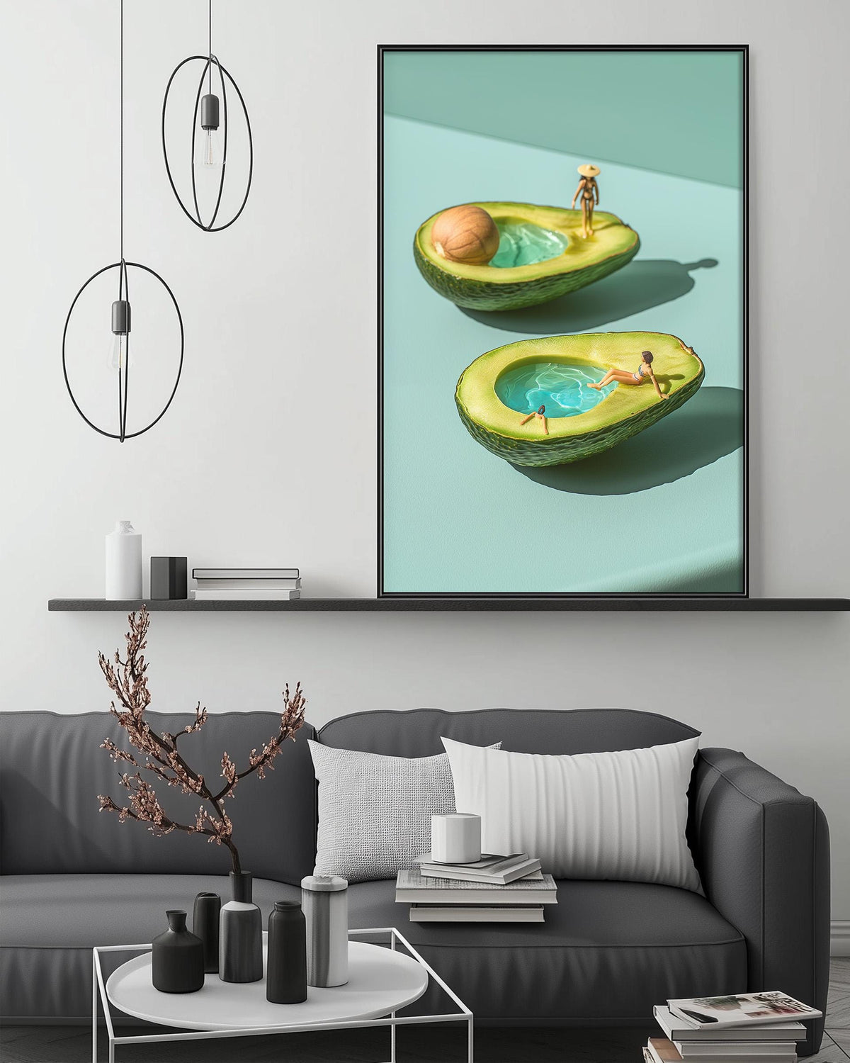 a modern living room with a gray sofa, a coffee table, and a large framed artwork depicting two avocados with people swimming in them.